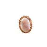 A gold ring set with large opal stone with white stone border,