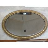 An oval gilt wall mirror