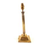 An Edwardian Corinthian column brass table lamp with wide stepped square base,