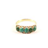 An unmarked gold ring set with five turquoise stones,