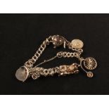 A silver charm bracelet set with various charms including car,