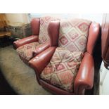 A pair of brown leather and cloth armchairs