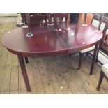 A mahogany oval extending dining table