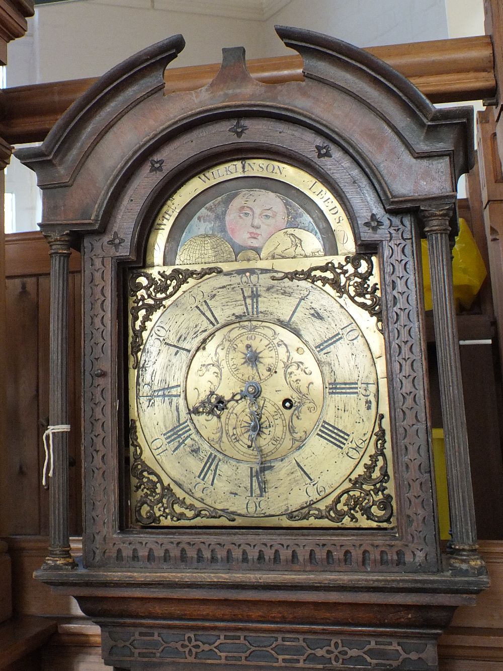 A 19th Century carved oak 8 day long cased clock with brass dial and moon roller by Wil Wilkinson,