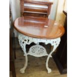 A circular mahogany top table on ornate cast iron base