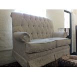 A modern beige upholstered two seater settee