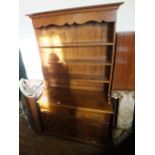 An oak shelf back dresser upon a two drawer two door base