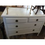 A white painted four drawer chest