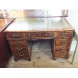 A mahogany and walnut nine drawer pedestal desk with green and gilt tooled skiver
