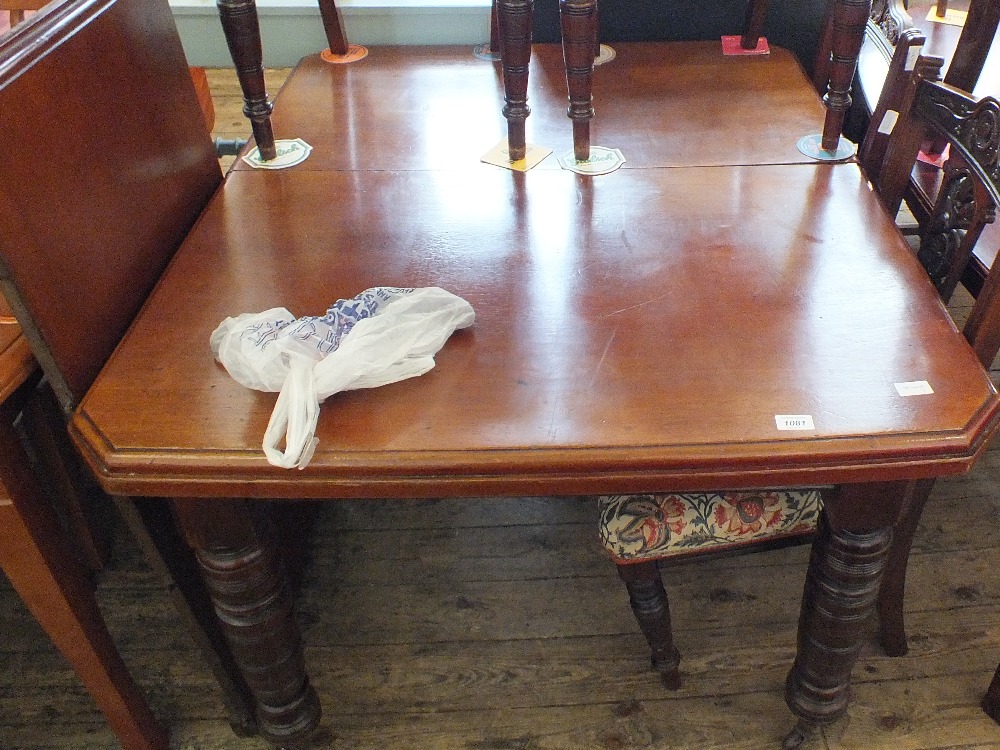 A Victorian mahogany extending dining table plus one leaf with canted corners on turned legs plus