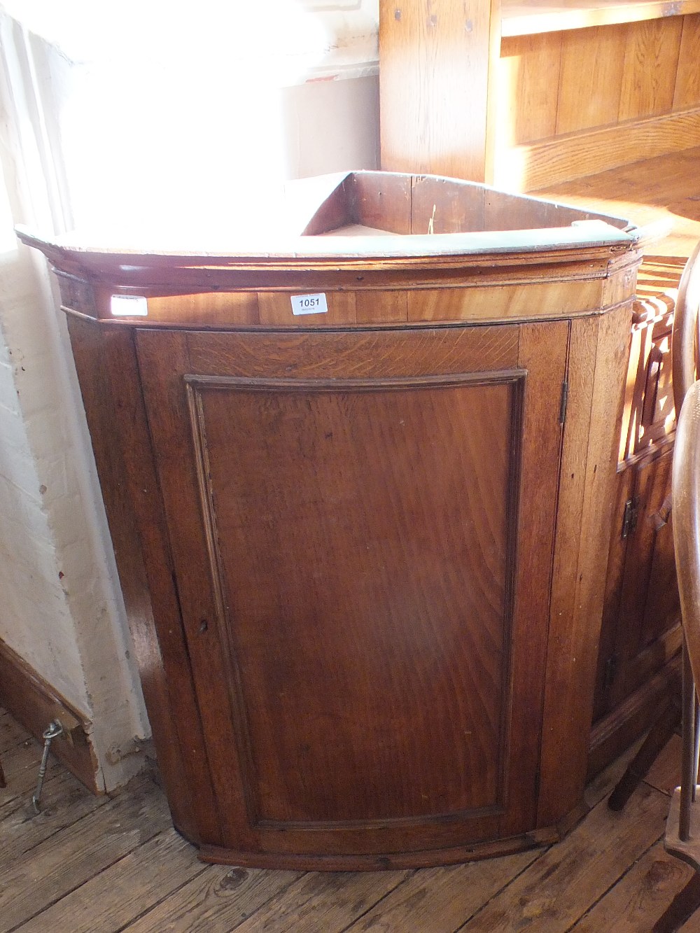 A 19th Century oak bow front corner cupboard