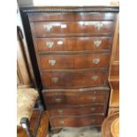 A reproduction mahogany serpentine front chest on chest
