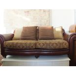 A brown leather and cloth three seater settee