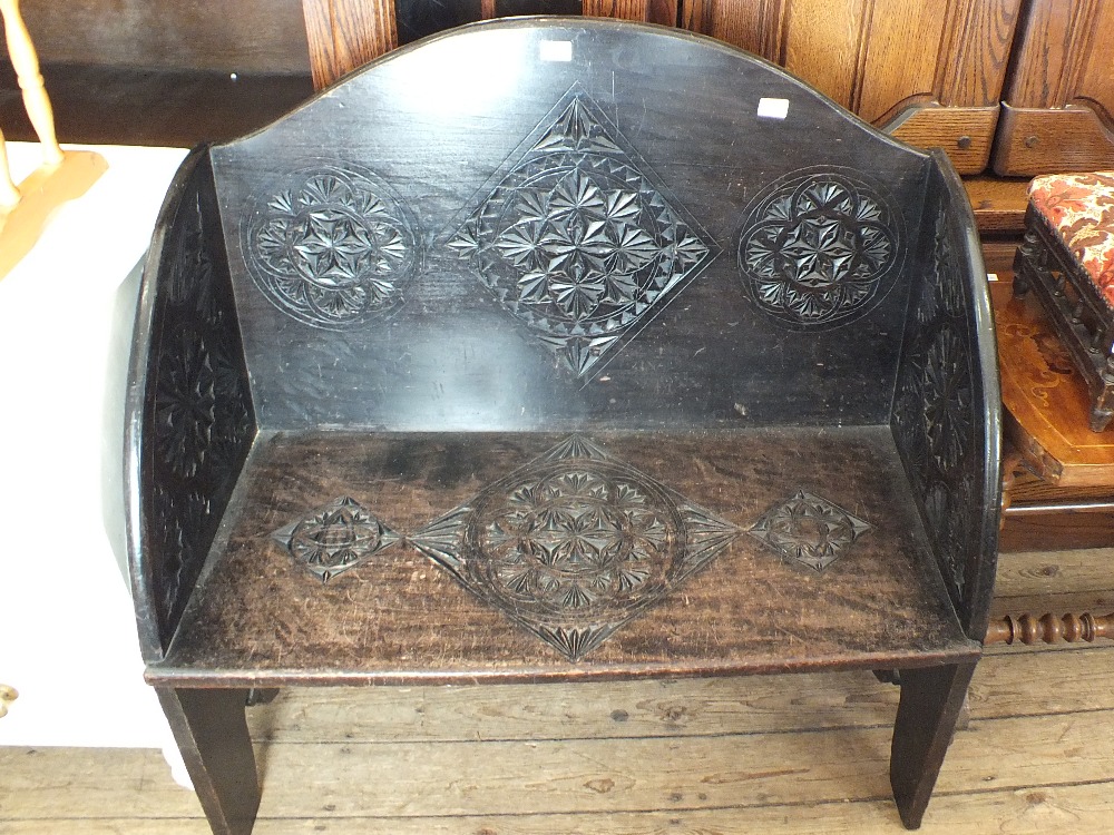 A carved oak arched top settle