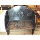 A carved oak arched top settle