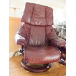 A maroon Stressless leather chair and stool