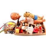 A collection of various sized dolls, tambourine, two die cast figures,