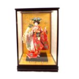 A Japanese dressed Geisha doll in glazed showcase