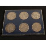 Six cased US silver dollars,