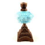 An iron base and blue glass oil lamp