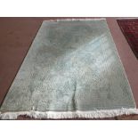 A New Zealand wood rug in green ground with floral design,