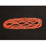 A four strand pink bead necklet with white metal clasp