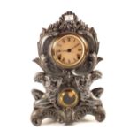 A striking mantel clock with cast metal front flanked by naked kneeling men (with fig leaves)