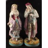 A pair of 19th Century continental figurines of a lady and a gentleman with polychrome floral