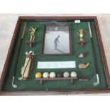 A glazed case of replica golfing items