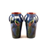 A pair of Torquay peacock decorated vases
