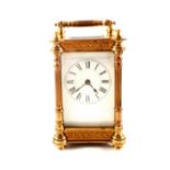 A carriage clock in ornate brass case (cracked dial)