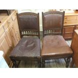 A set of four oak and maroon leather dining chairs