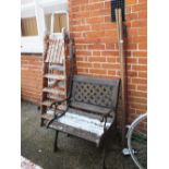 A cast iron and wooden garden chair, tools,