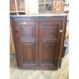 A wall hanging oak two door corner cupboard