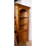 A pine corner cupboard with three shelves and cupboard below