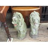 A pair of weathered concrete lion garden statues