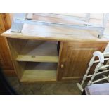 A pine single door cupboard with two shelves