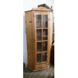 A glazed single door pine corner cupboard with single drawer