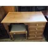 A light pine desk with four drawers and a pine upholstered stool