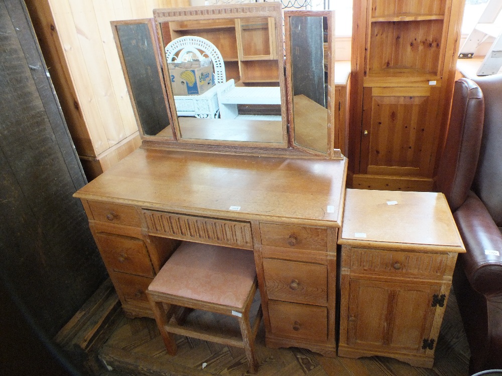 A limed oak dressing table with nine drawers,