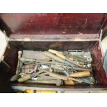 A pine tool chest containing various chisels, planes,