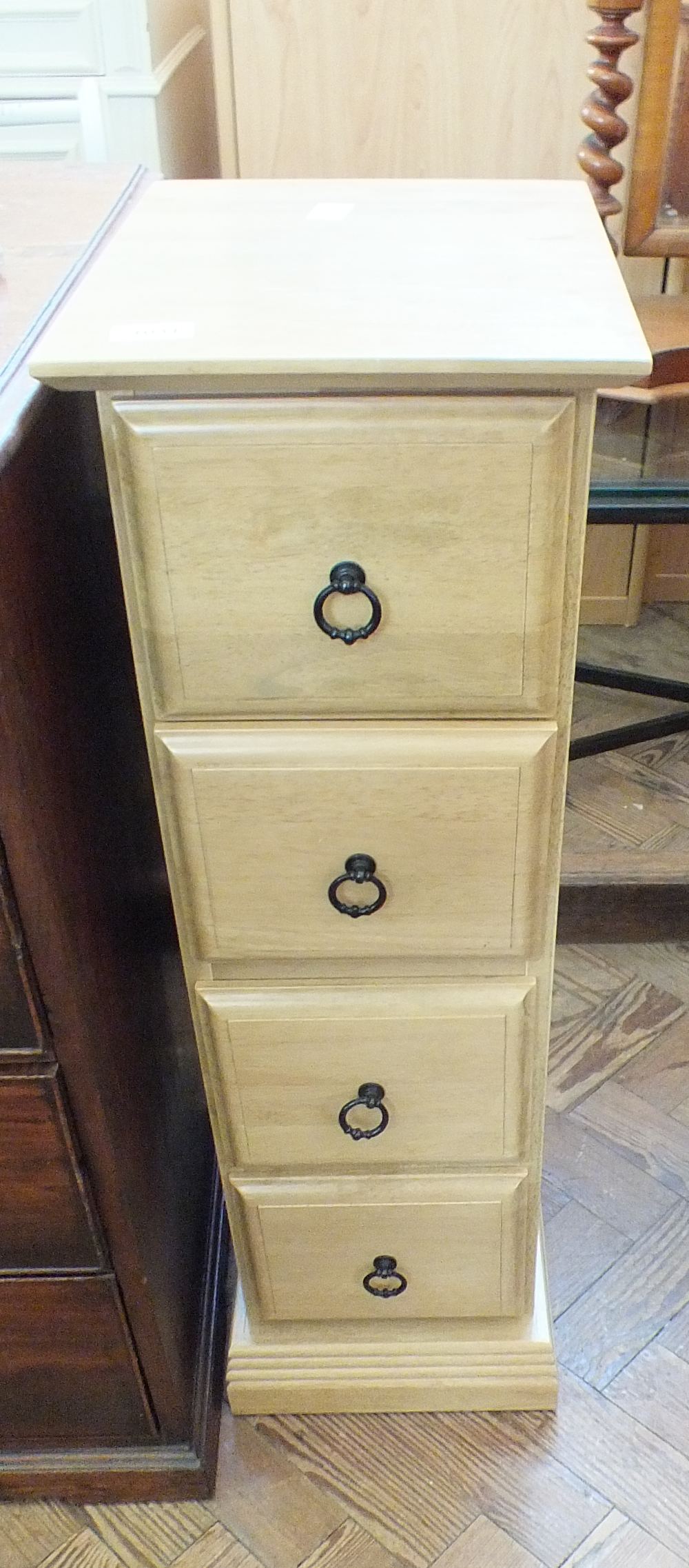 A modern oak effect narrow chest of four drawers