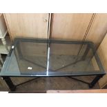 A metal based rectangular glass top coffee table