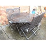 A teak outdoor table and four chairs