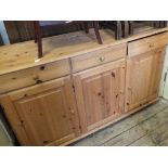 A modern pine three drawer, three door sideboard,