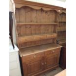 A light pine two drawer kitchen shelf back dresser