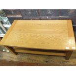 A light oak coffee table with shelf below,