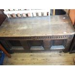 An oak chest with two plank lid and three carved panelled front,