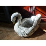 A large weathered concrete garden planter in the form of a swan