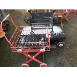 A black painted cast iron fire grate and two trolleys